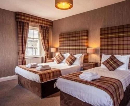 a hotel room with two beds and a window at The Sun Hotel in Warkworth