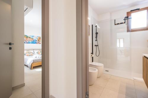 a bathroom with a toilet and a bed at Domus Luna in Teulada