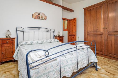 a bedroom with a bed and a wooden cabinet at Villa Montalmutu con vista mare in Nuragheddu