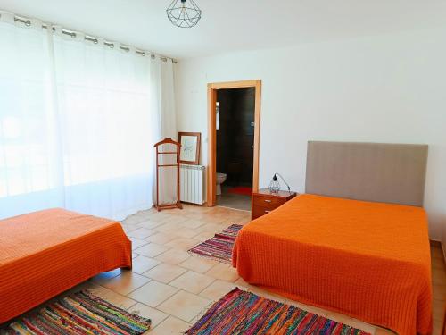a bedroom with two beds and a window at Casa da Nelita in São Martinho do Porto