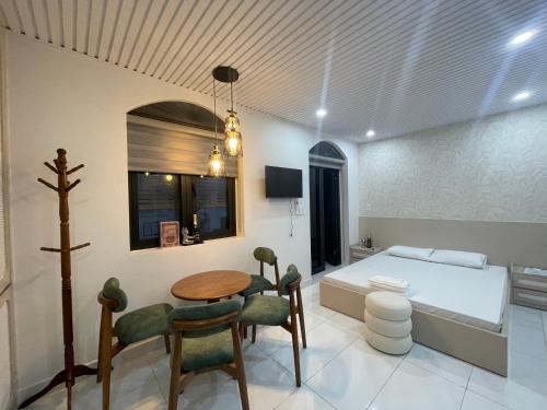 a bedroom with a bed and a table and chairs at Sunrise Apartments in Xóm Niêm