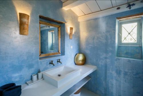 a bathroom with a white sink and a mirror at Villa Aeolus Stylish Villa with Pool Masterbedroom with seperate Mezzanine in Koríthion