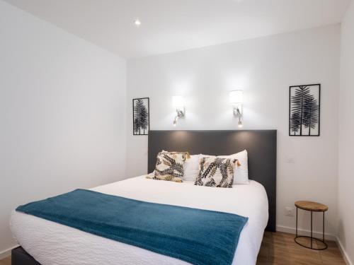 a bedroom with a large bed with a blue blanket at Gites Au Point De Vue in Perros-Guirec