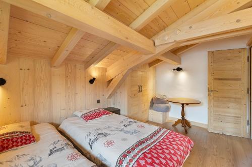 a bedroom with two beds in a room with wooden ceilings at Chalet Individuel - Saflalou in Combloux