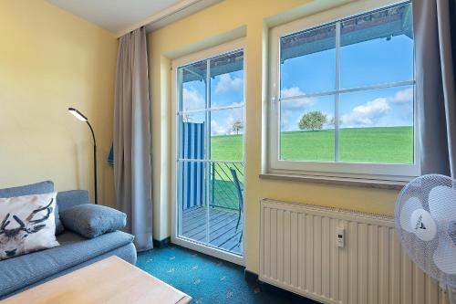 a living room with a couch and a window at Apartment mit Gartenblick K1 106 in Spalt