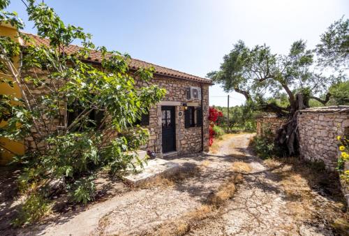 a stone house with a gate and a driveway at Stavlo Open Plan Cottage Zakynthos in Koríthion