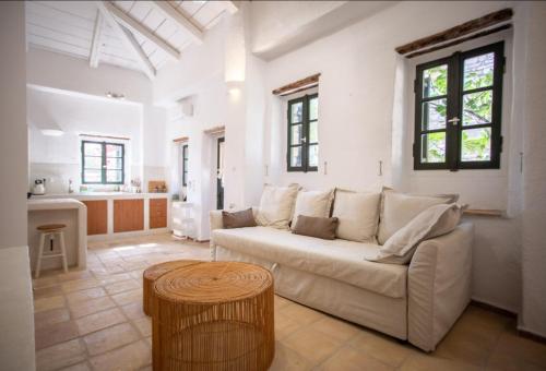 a living room with a couch and a table at Stavlo Open Plan Cottage Zakynthos in Koríthion