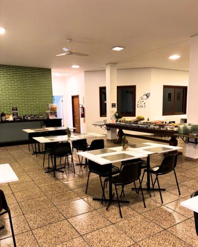 a cafeteria with tables and chairs in a room at Canas Gold Praia Hotel in Florianópolis