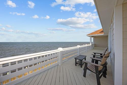 a balcony of a house with two chairs and the ocean at 7659 - Sound Garden in Avon