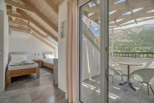 a room with a balcony with a bed and a table at Villa Pilali in Kefallonia