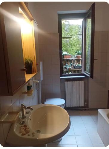 a bathroom with a sink and a toilet and a window at Casa Lu' in Bosisio Parini