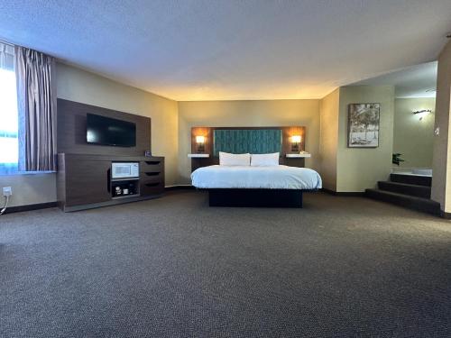 a hotel room with a bed and a flat screen tv at Travelodge by Wyndham Amherst in Amherst