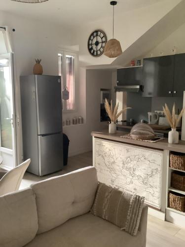 a kitchen with a couch and a refrigerator at Jul'Home pour 4 personnes , Terrasse avec Jacuzzi en centre ville Dax in Dax