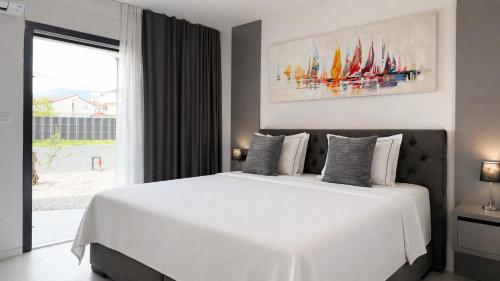 a bedroom with a large white bed and a window at Moonlight Luxury Apartment with Private Pool and Parking in Kaštela
