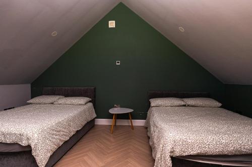 two beds in a room with a green wall at Wild Atlantic Camp in Creeslough