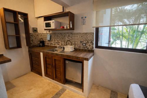 a small kitchen with a sink and a window at Villas Palmar Holbox in Holbox Island
