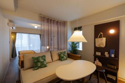 a living room with a couch and a table at The Apartment Hotel Shibuya 3 in Tokyo