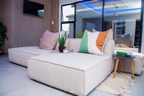 a couch with colorful pillows on it in a room at Overflow Accommodation Lodge in Louis Trichardt