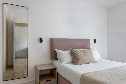 a bedroom with a mirror next to a bed at Calido Alcobendas in Alcobendas
