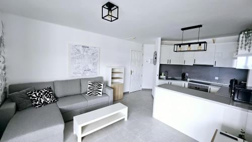 a living room with a couch and a kitchen at ELKO Apartman in Mogán