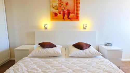 a bedroom with a bed with two pillows on it at Residenz am Yachthafen 14 in Grömitz