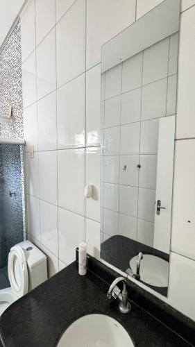 a bathroom with a sink and a toilet and a mirror at Casa jatobá in Petrolina
