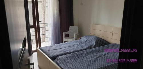 a bedroom with a bed and a window and a chair at SHEKVETILI s in Kokotauri