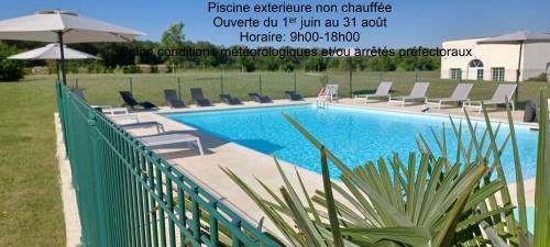 a swimming pool with chairs and umbrellas next to a fence at Résidence Villa Bellagio Amboise by Popinns in Amboise