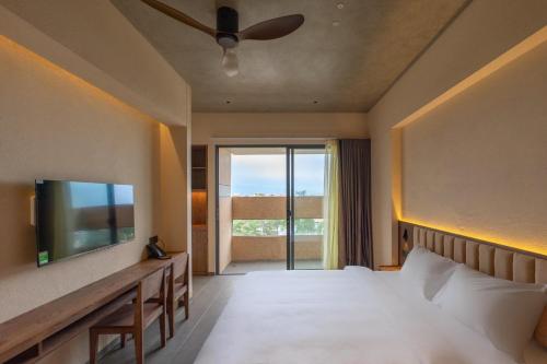 a hotel room with a bed and a television at The Charm Hotel Phan Thiet in Ấp Bình Hưng