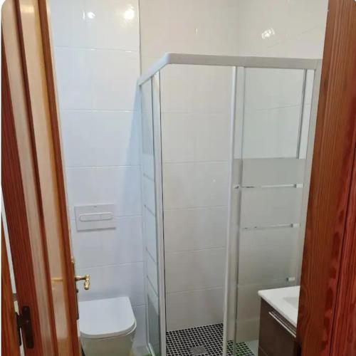 a bathroom with a toilet and a glass shower at Casa Ingrid in San Fulgencio