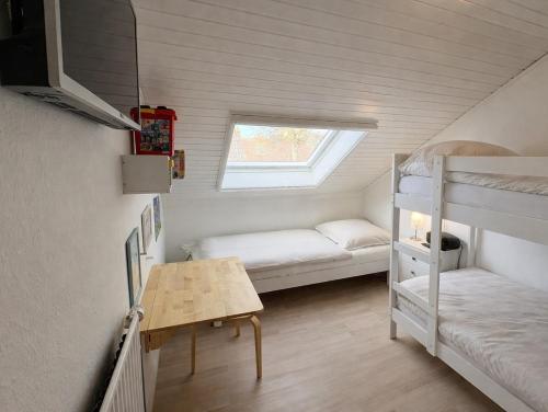 a small room with two bunk beds and a desk at Sand & Siel Dangast in Dangast