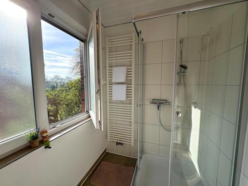 a bathroom with a shower and a window at Sand & Siel Dangast in Dangast