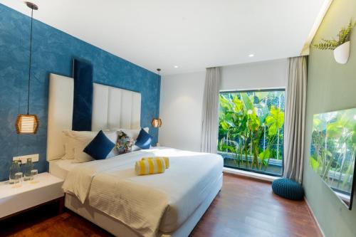 a bedroom with a large bed and a large window at DARZA LUXURY RESORTs in Coimbatore