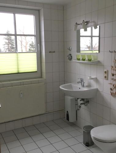 a white bathroom with a sink and a toilet at Nixe in Timmendorf