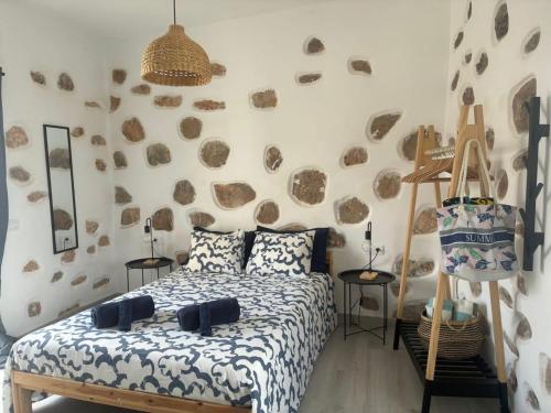 a bedroom with a bed and a rock wall at Apartment Estrella Nina in La Ampuyenta