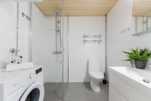 a bathroom with a washing machine and a toilet at Luminary - Tampere City Center Apartments by Come in! in Tampere