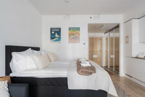 a bedroom with a large bed with a towel on it at Luminary - Tampere City Center Apartments by Come in! in Tampere