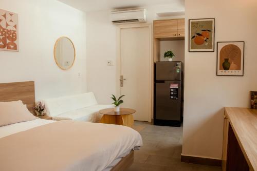a small room with a bed and a refrigerator at Fair Dinkum Stay District 1 in Ho Chi Minh City