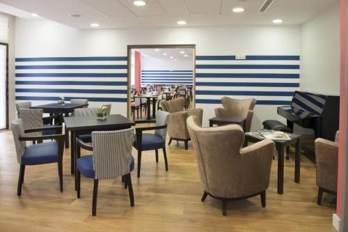 a restaurant with tables and chairs and a mirror at DOMITYS - Le Ruban d'Azur in Sète