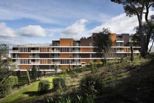 a large building on a hill with trees and bushes at DOMITYS - Le Ruban d'Azur in Sète