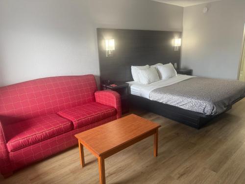 a hotel room with a bed and a red couch at Econo Lodge Naval Station Norfolk in Norfolk