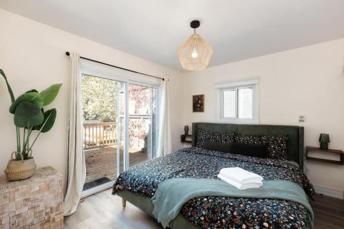 ein Schlafzimmer mit einem Bett und einem großen Fenster in der Unterkunft The River Nest in Bracebridge