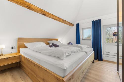 a bedroom with two large beds with blue curtains at Up Böhn in Krummhörn