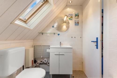 a bathroom with a white toilet and a sink at Up Böhn in Krummhörn