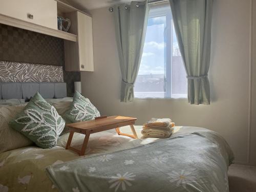 a bedroom with a bed with a table next to a window at Hares Haven pet friendly sleeps 6 in Patrington