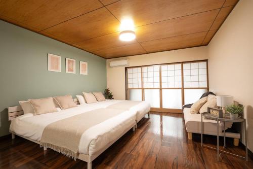 a large bedroom with a large bed and a couch at Staylinks Nara Kitamachi in Nara