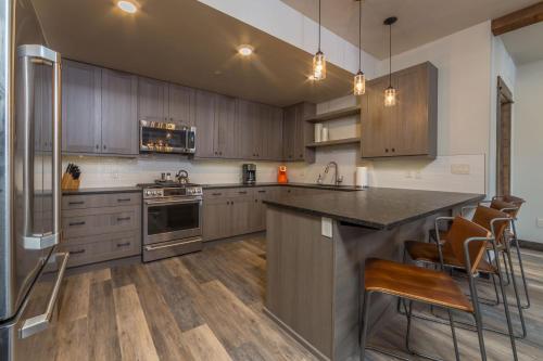 a kitchen with wooden cabinets and stainless steel appliances at Mountain Lake Condo - Unit 102B in Big Sky