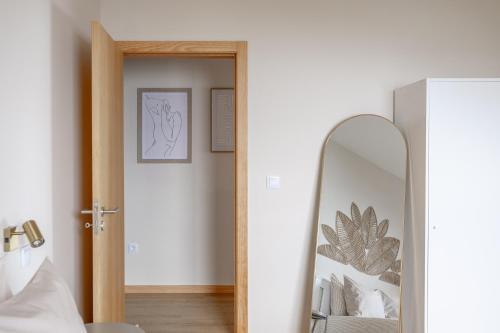 a mirror in a room next to a bedroom at Endless Horizon BY YOUR KEY MADEIRA in Santa Cruz