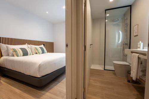 a bedroom with a bed and a bathroom with a shower at Silken Puerta de Irati in Ochagavía