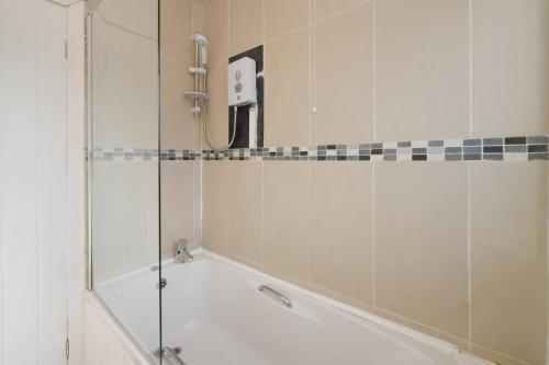 a bathroom with a shower and a bath tub at Goldie Apartment 2BR flat in Dalry